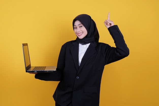 The woman was wearing a black suit and dark pants, holding a laptop holding hands up in success