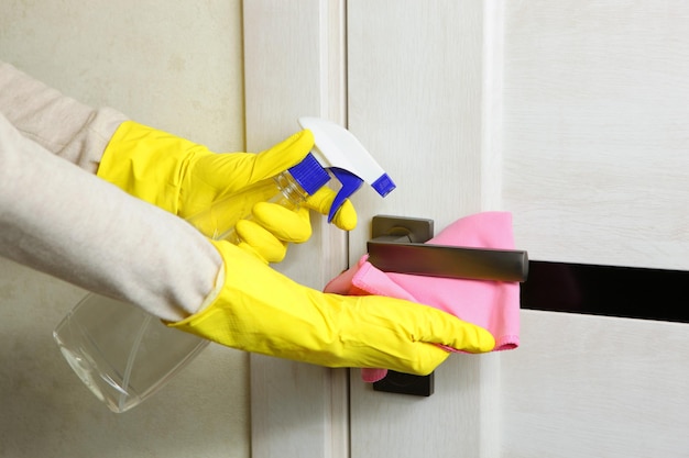 The woman washes and disinfects the doorknob prevention of the spread viruses