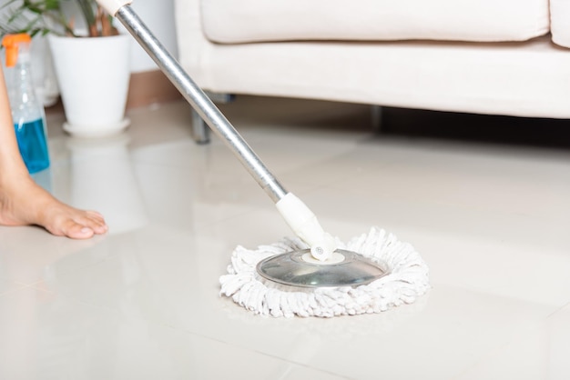 Photo woman washes the floor with a mop and rag indoors housewife washing floor mopping at home