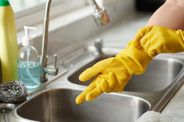 Woman washing dishes in gloves