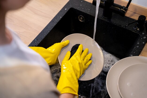 キッチンで皿洗いをする女性の手主婦のきれいな皿の接写
