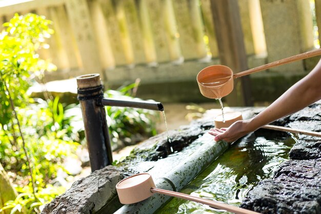 日本のお寺に行く前に手を洗う女性