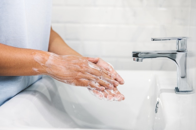 Woman Washing hands to prevent spread of CoronaVirus as well as cold, flu, bacteria at home