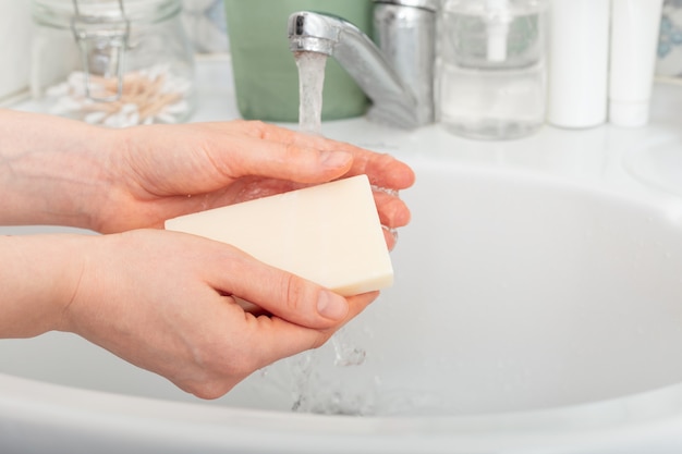 Mani di lavaggio della donna con acqua e sapone