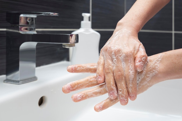 Woman washing hands with soap