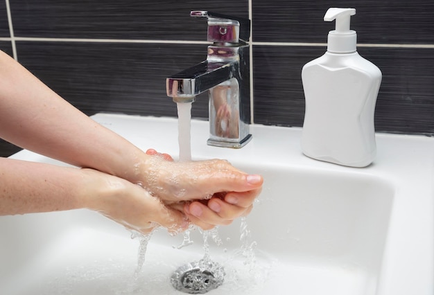 Женщина моет руки с мылом