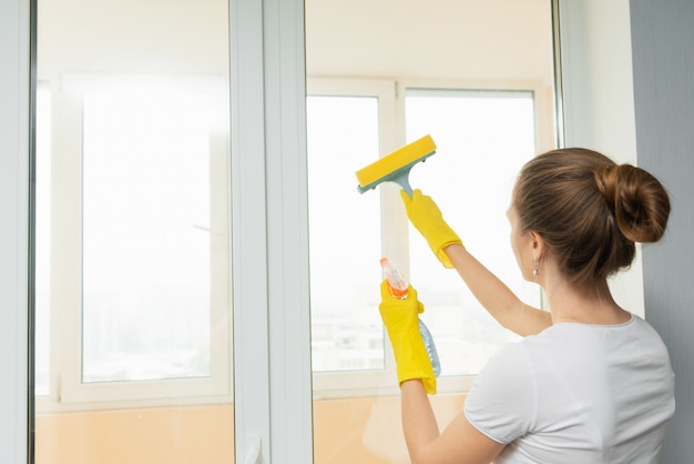 Photo woman washing a window with a scraper