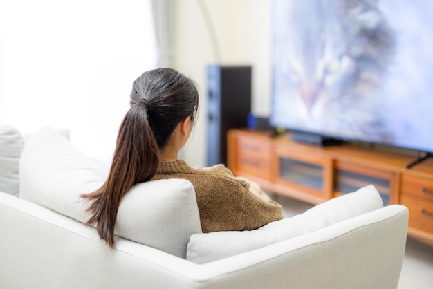 写真 女性は家でテレビを見る