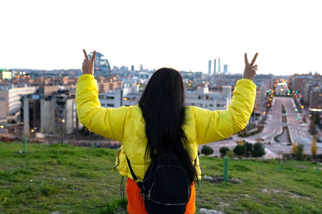 Woman watching the city from the top of a hill