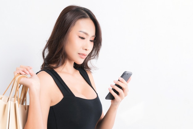 woman watching her phone while carrying a bag