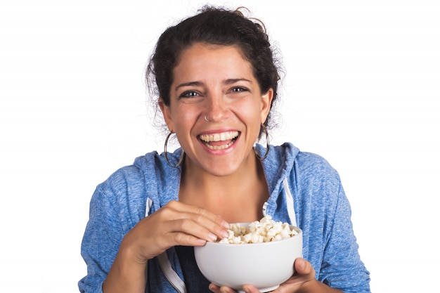 Woman watching a movie while eating popcorn.