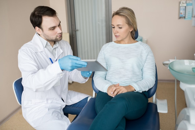 Woman watching tablet with dentist