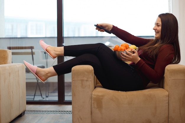 Woman watching tv and smiling.