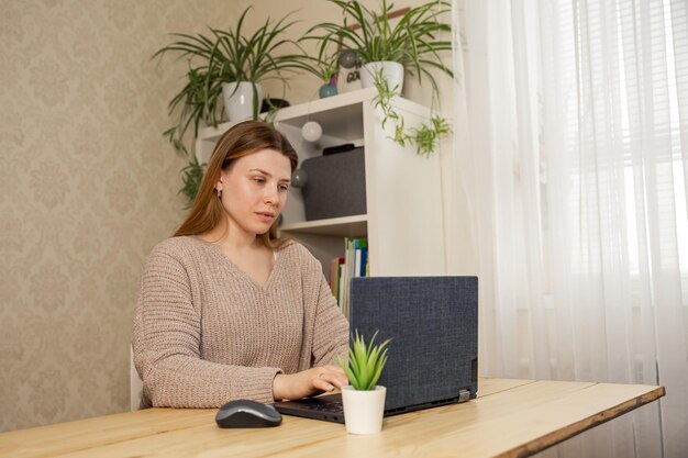 Photo woman watching webinar at computer female remote working from home