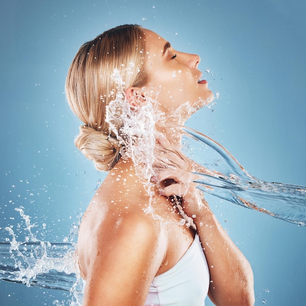 Foto donna acqua e idratazione per l'igiene dei cosmetici per la cura della pelle di bellezza o umidità pulita su uno sfondo blu da studio rilassamento femminile nella pulizia della cura del corpo per una pelle idratata di lusso o un trattamento cosmetico