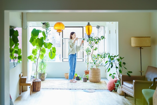 観葉植物に水をまく女性