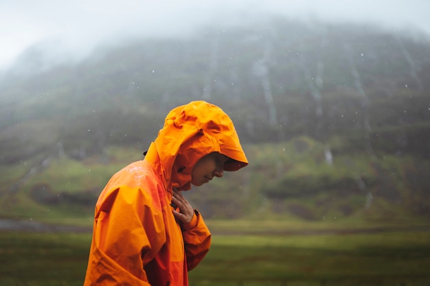 Donna in giacca impermeabile durante il trekking negli altopiani