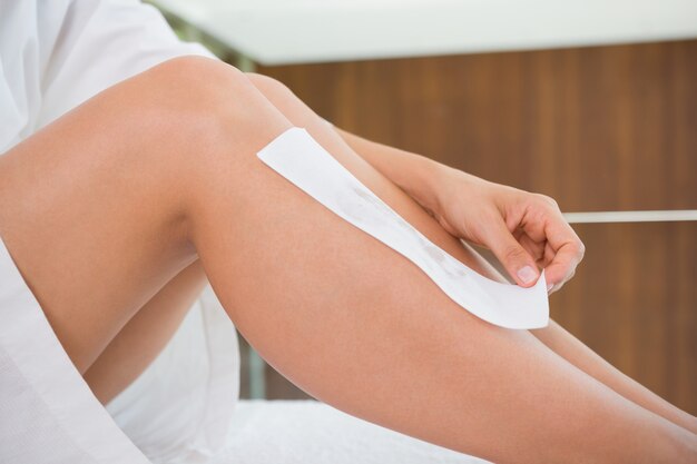 Woman waxing her legs herself