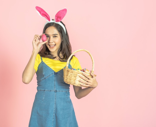 Woman wear bunny ear and hold easter egg cover eye