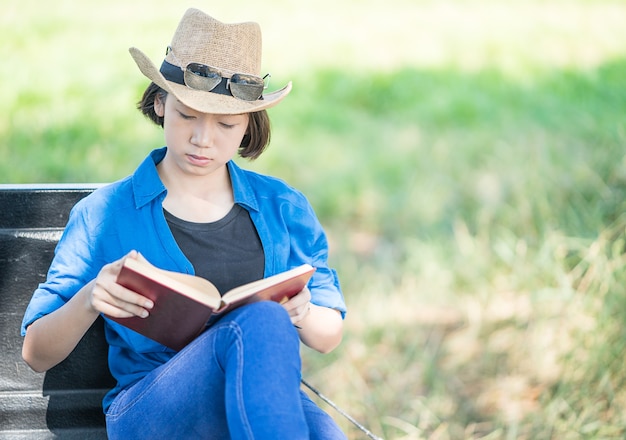 Woman wear hat and reading the book on pickup truck