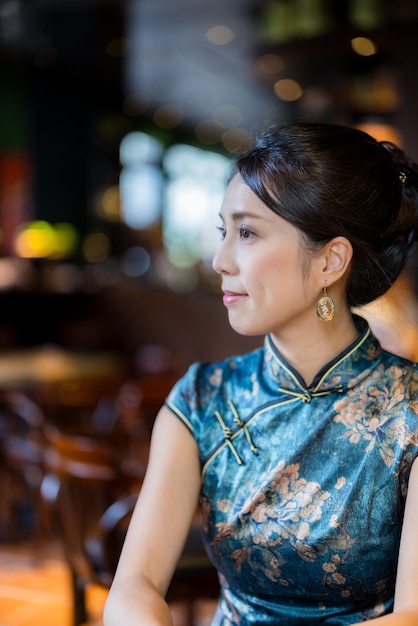 Woman wear traditional cheongsam in the restaurant