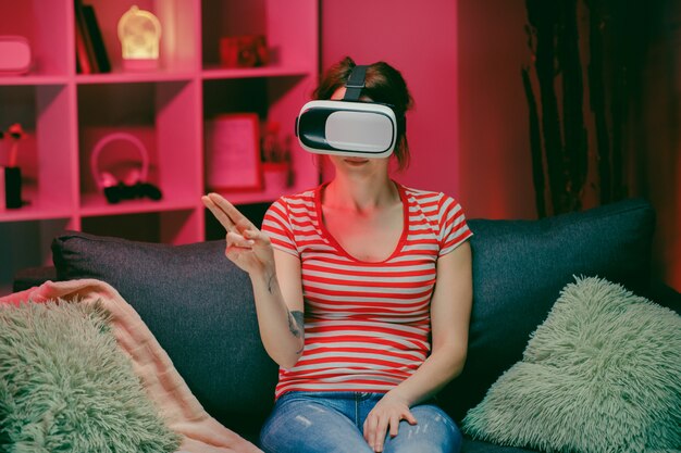 Woman wear VR headset and touch virtual screen at night