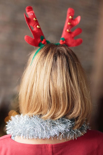 Woman wearing antler deer headband rear view