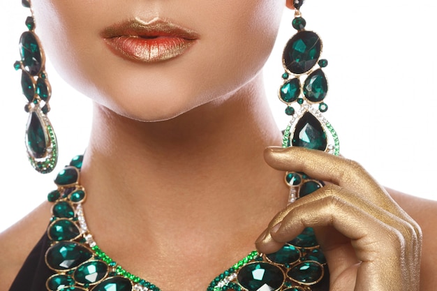  woman wearing big beautiful necklace and earrings with a lot of gems