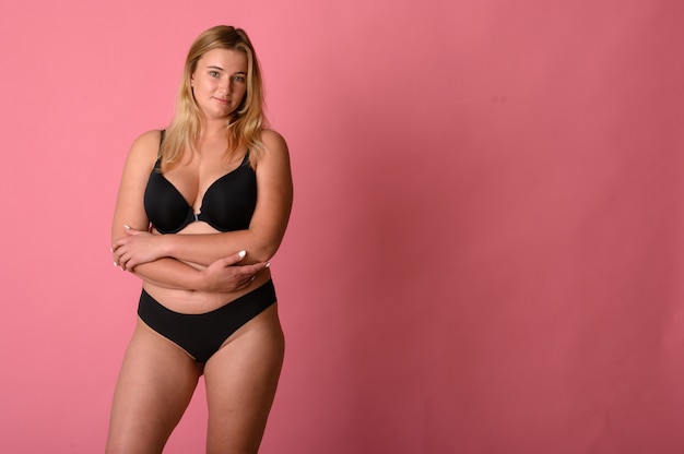woman wearing black bikini measures the size of the waist