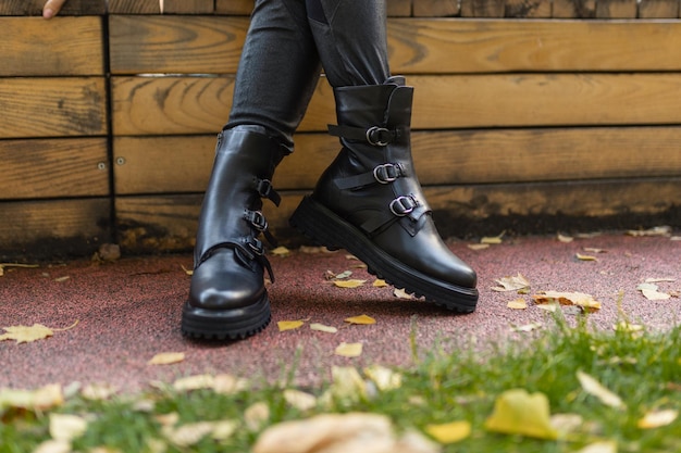 A woman wearing black boots with the word gucci on the bottom.