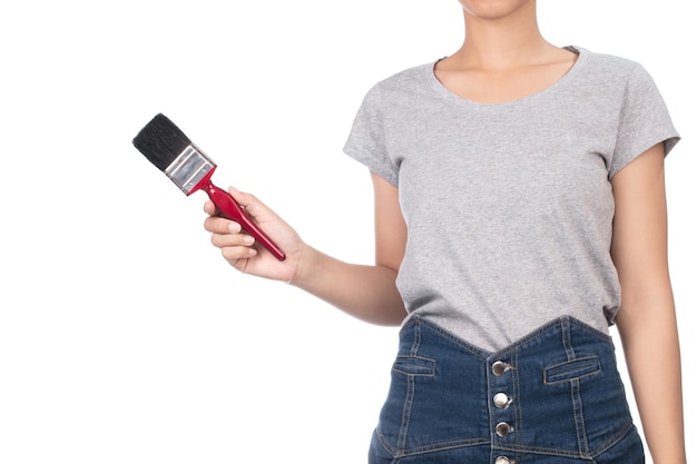 woman wearing blank gray t-shirt, jeans holding paintbrush isolated on white background