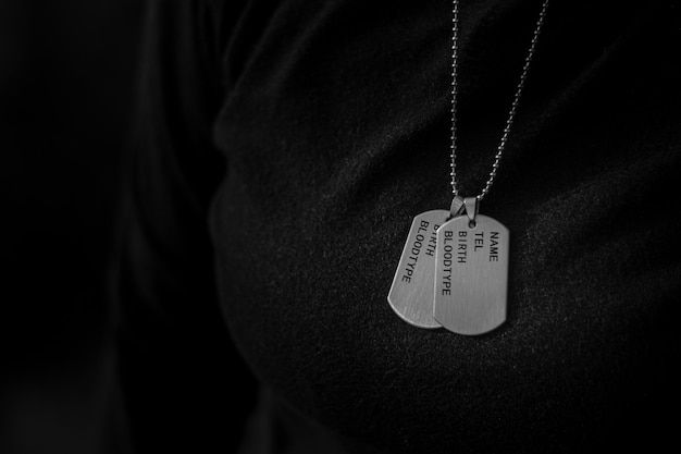 A woman wearing a blank military dog tags. - Memories and sacrifices concept.