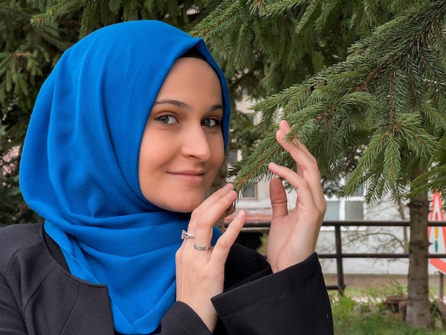 A woman wearing a blue hijab and a black jacket