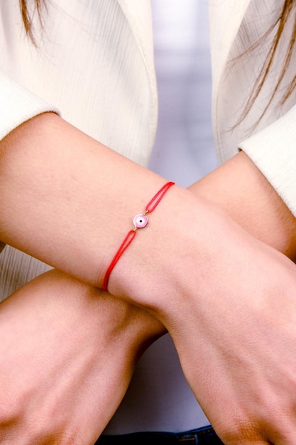 a woman wearing a bracelet with a pearl on it