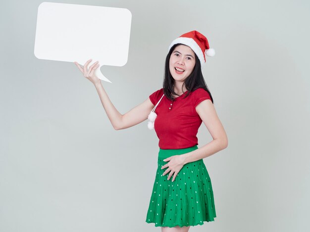 空のプラカードを示すクリスマス帽子をかぶっている女性