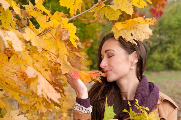 Woman wearing coat standing by tree in park during autumn