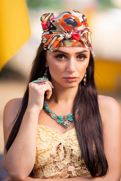 Photo a woman wearing a colorful headband and a headband stands in front of a yellow background.