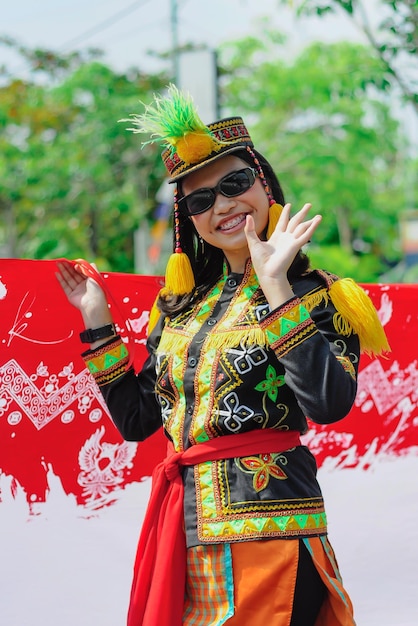 A woman wearing a colorful outfit with a red umbrella in the background