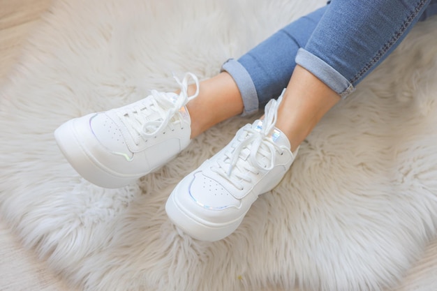 Woman wearing comfortable stylish sneakers indoors closeup