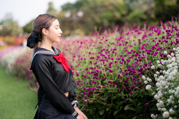 屋外の公園でコスプレ日本の制服を着ている女性