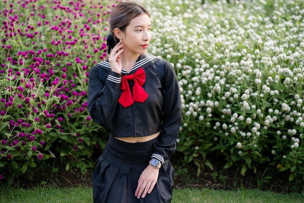 Woman wearing cosplay Japanese school uniform at park outdoor