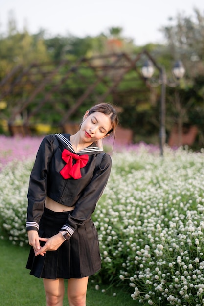 屋外の公園でコスプレ日本の制服を着ている女性