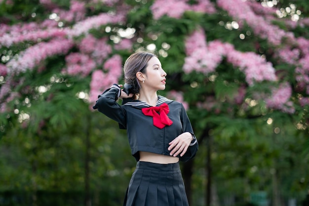 Woman wearing cosplay Japanese school uniform at park outdoor