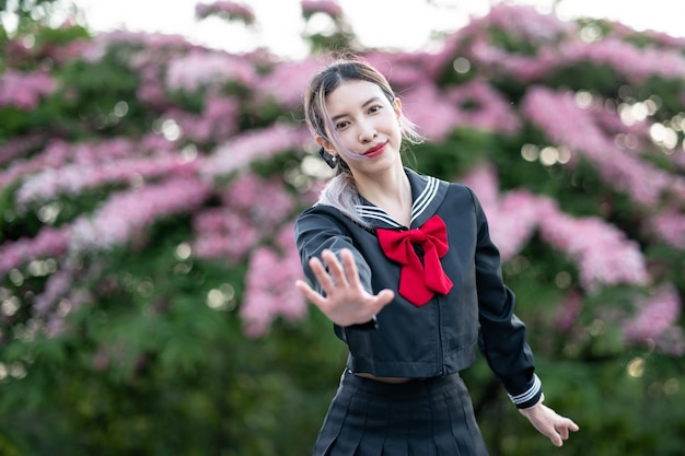 Donna che indossa l'uniforme scolastica giapponese cosplay al parco all'aperto