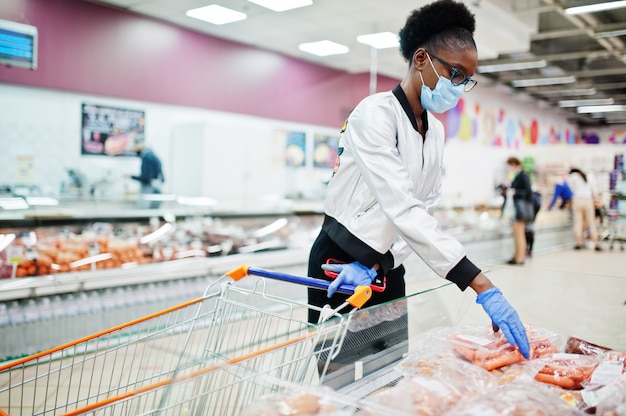 woman wearing disposable medical mask and gloves shopping in supermarket during coronavirus pandemia outbreak