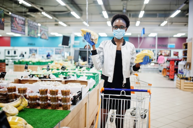 woman wearing disposable medical mask and gloves shopping in supermarket during coronavirus pandemia outbreak.