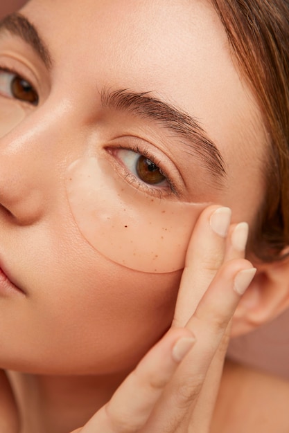 Photo woman wearing eye patches close up