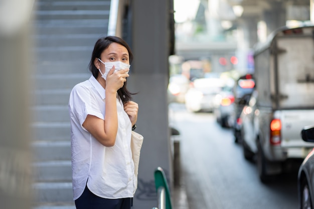 フェイスマスクを身に着けている女性は大気汚染（PM2.5）からフィルターを保護します