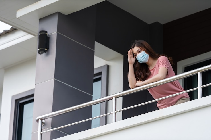 Photo woman wearing a face mask and quarantine in balcony of her home, coronavirus (covid-19) pandemic concept