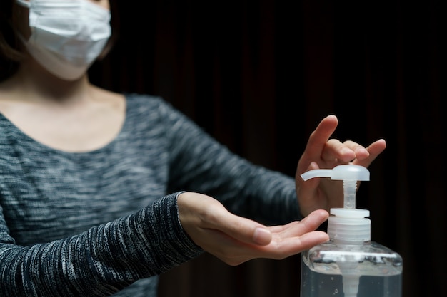 Woman wearing a face mask and using sanitizer